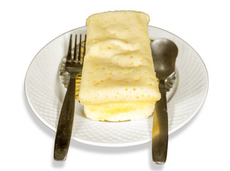 white chocolate cheese cake with teaspoon and fork on kitchen foil, white ceramic plate and isolated on white background.