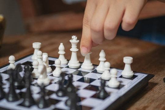 Image of female hand is playing chess.