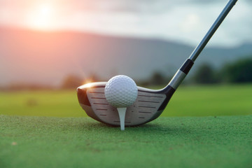 Golf ball and golf club in beautiful golf course at sunset background. Golf ball on green in golf course at Thailand