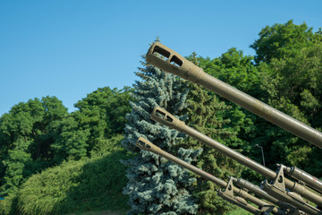 Barrels of artillery against a blue sky. The concept of war and violence