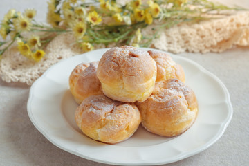 Cream puffs on white plate.