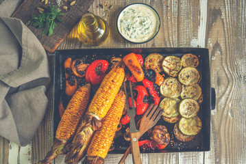Top view of rustic kitchen table with grilled vegetables on wooden vintage table. Organic vegetables ready to eating.