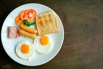 Top view of American breakfast on dark brown wooden table.