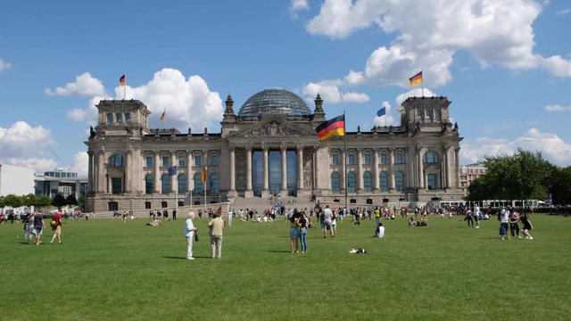  Many people in front of the Reichstag building (German Bundestag), a famous classic landmark on a sunny, summer day