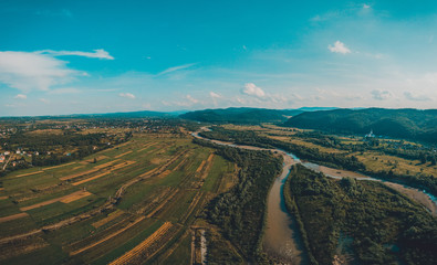 Rural landscape in the low mountains of the Western Carpathians, visible mountain river and fields.