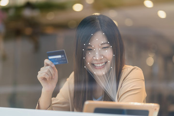 Asian women using the technology tablet for access control by face recognition in private identification step when online shopping with the credit card, credit card mockup, online payment concept,