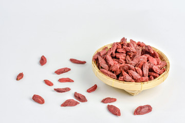 Goji berries in small bamboo basket container,shot on white background.