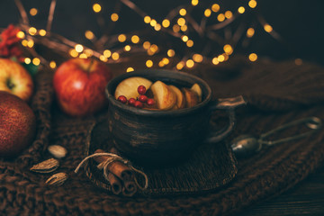 Cup of hot apple tea for fresh start of the day. Autumn season warm drink. Copy space on wood background. Toned image. Selective focus.