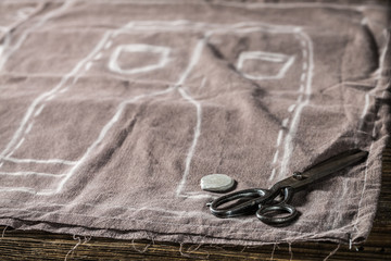 Scissors, cloth and tailor draft of trousers in tailoring workshop