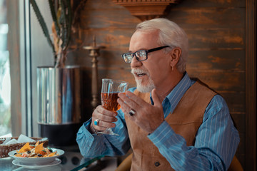 Man wearing ring and ear ring drinking alcohol