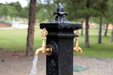 A metal fountain in the city park