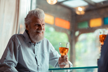 Bearded man smiling while speaking with friend