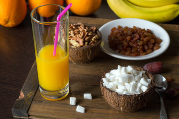 Delicious raw diet breakfast on wooden table. Coconut meat and kernels of walnut in bowls from coconut shell.