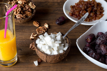 A cup of coconut shell filled with cubes of coconut pulp and a spoon inside. Healthy eating concept.