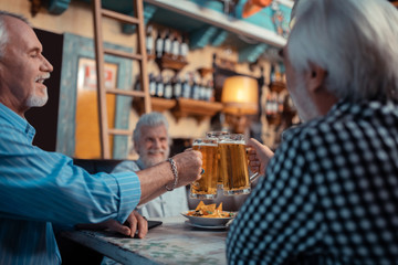 Three grey-haired men chilling and drinking beer
