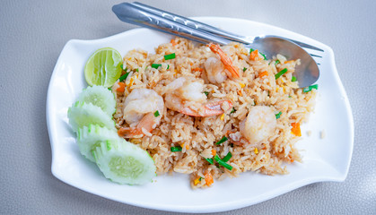 Thai food, Shrimp fried rice In a white plate ready Vegetables placed in the dish.