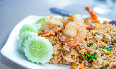 Thai food, Shrimp fried rice In a white plate ready Vegetables placed in the dish.