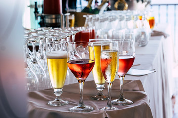 Set of coloured glasses at the restaurant with wines and. beer - concept. of celebration and catering work - defocused background with bar
