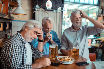 Three pensioners feeling dissatisfied after watching football - obrazy, fototapety, plakaty