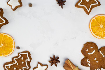 Frame from spices, Christmas cookies, gingerbread man, oranges on white concrete background. Recipe, invitation concept. Top view, flat lay, close-up, copy space, layout design