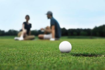 Golf ball near hole on green course