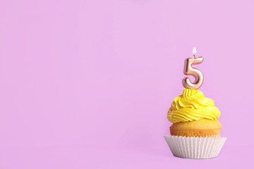 Birthday cupcake with number five candle on violet background, space for text