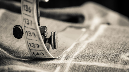 Closeup of vintage tailor machine with scissors, cloth and threads