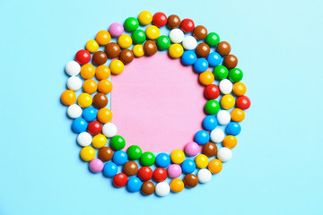 Frame made of delicious candies on color background, top view. Space for text
