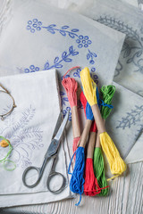 Top view of colored threads and embroidered napkins