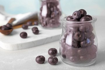 Jar of fresh acai berries on stone table, closeup. Space for text