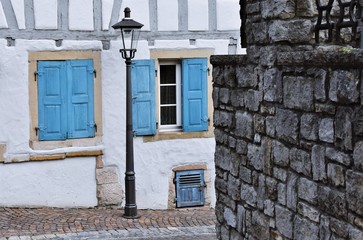 Naklejka na ściany i meble Close up of a Street lamp and windows with blue shutters
