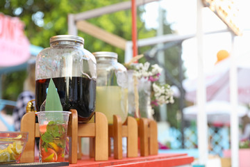 Glass jars with refreshing drinks on table outdoors