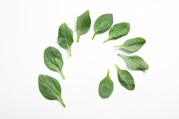 Frame made of fresh green healthy spinach leaves on white background, top view