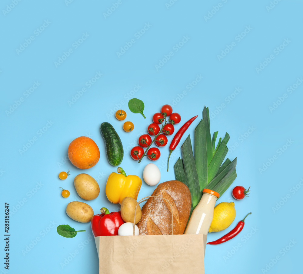 Canvas Prints Shopping paper bag with different groceries on light blue background, flat lay