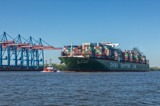 Hamburg, Germany - May 8, 2018: Tug boat ZP BOXER maneuvering container vessel CSCL MARS to its berth at the port of Hamburg