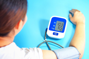Health concept, young women are measuring blood pressure with a blood pressure monitor. (Blood...