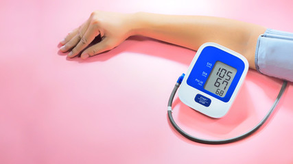 Health concept, young women are measuring blood pressure with a blood pressure monitor. (Blood pressure measurement device is not specific to the brand)