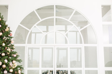 Arch door in light room. Christmas presents/gifts under fir-tree. Vintage New Year decorations....
