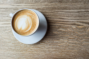 Obraz na płótnie Canvas White cup of coffee on wood table background