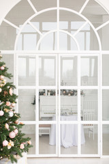 Arch door in light room. Christmas presents/gifts under fir-tree. Vintage New Year decorations. gift boxes and lantern under fir-tree. Christmas mood. Celebrating of New Year