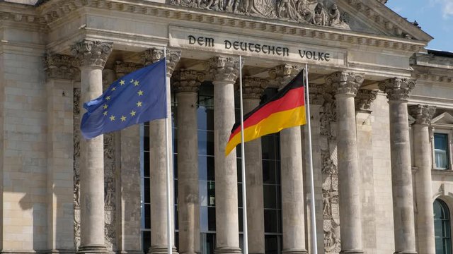 The flag of Germany and the European Union at the Reichstag building in Berlin, Germany