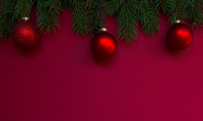 Christmas composition. Fresh fir tree branches, decorations on red background. Christmas, winter, new year concept. Flat lay, top view, copy space.