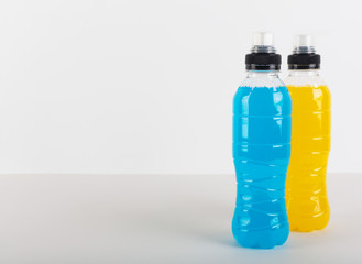 Isotonic energy drink. Bottles with blue and yellow transparent liquid, sport beverage on a white...