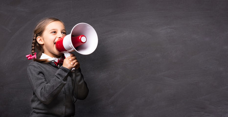 Child Girl Student Shouting Through Megaphone on Blackboard Back