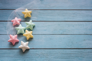 Many colorful props stars placed on blue wooden boards to form a fashion dream copy space