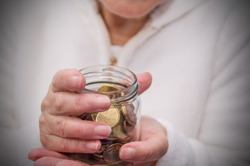 woman hands with glass jar and coins, saving concept