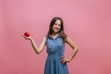 Girl holding red Apple on pink background