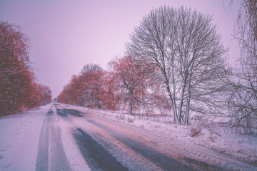 Winter country road. Winter rural landscape. The road in the early frosty morning. Landscape with the country road covered with snow. Winter travel concept