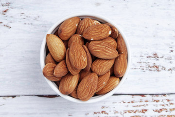 A small bowl with almond at white background