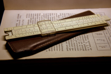 A slide rule lying on the open book